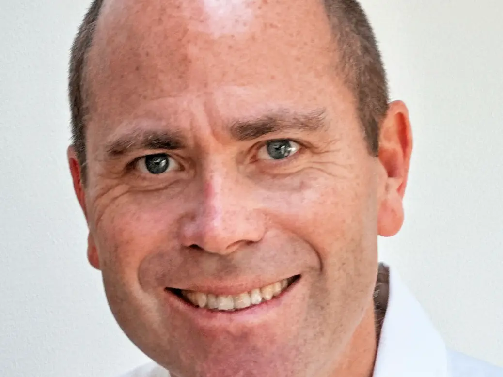 Robert Winnett wearing a collared shirt and smiling at the camera