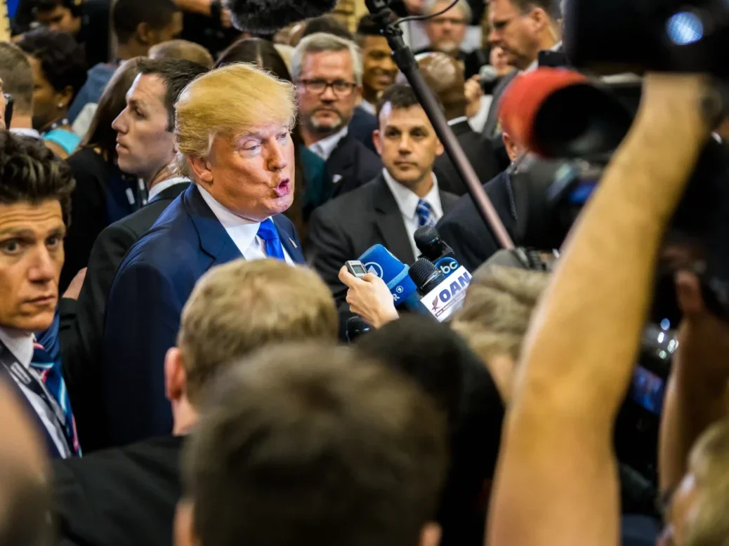 President Donald Trump talks to the media at a public press event following the RNC debate in Houston, Texas. The picture illustrates a data piece looking at how web traffic to top news publishers over the 2024 election differed from 2020.